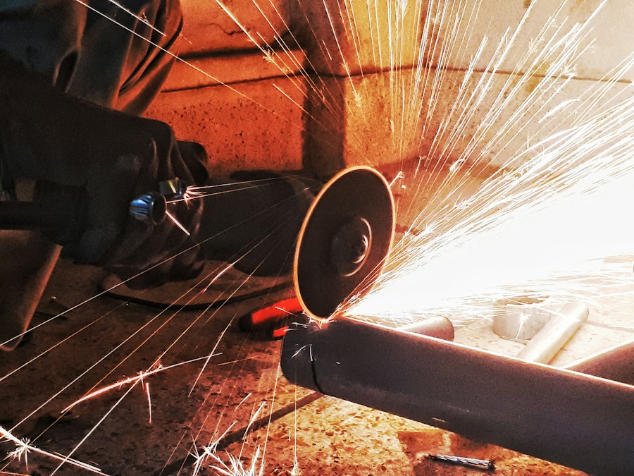 Meuleuse d’angle avec disque à tronçonner coupant un tube en acier